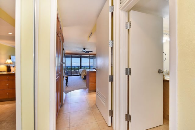 hallway featuring expansive windows and light tile patterned floors