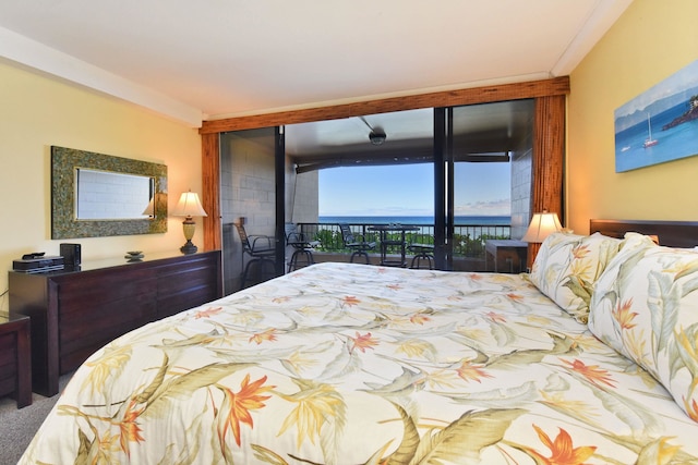 carpeted bedroom featuring a water view, ornamental molding, and access to outside