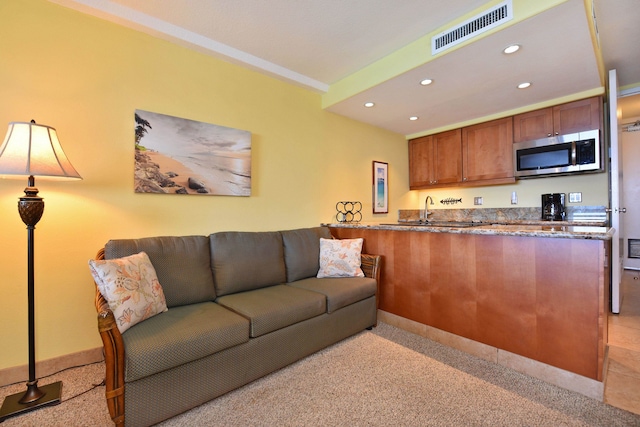 living room with light colored carpet and sink