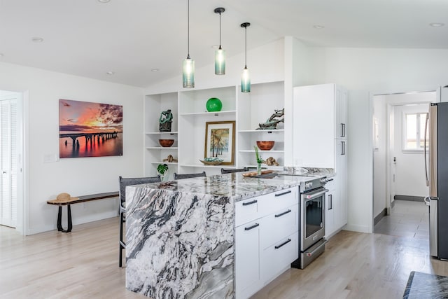 kitchen with stainless steel appliances, white cabinetry, light stone countertops, and vaulted ceiling