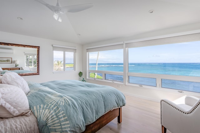 bedroom with light wood-type flooring, ceiling fan, a water view, an AC wall unit, and lofted ceiling