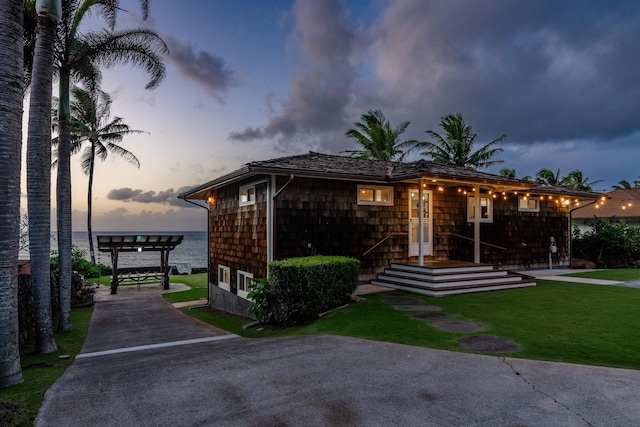 view of front of property featuring a yard and a water view