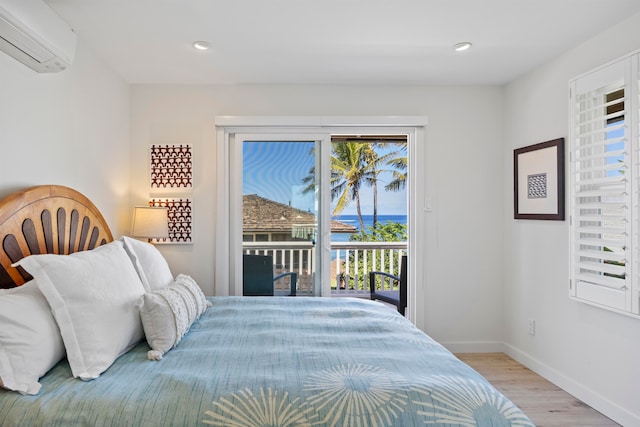 bedroom featuring access to exterior, light hardwood / wood-style floors, and a wall mounted AC