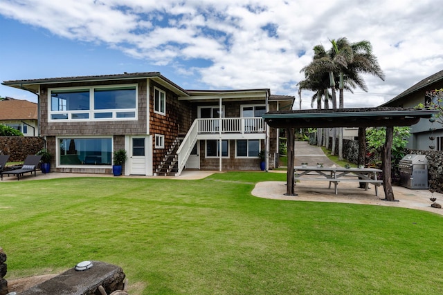 rear view of house featuring a patio and a lawn