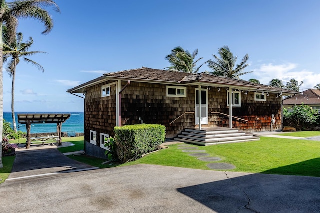 view of front of property with a water view and a front lawn