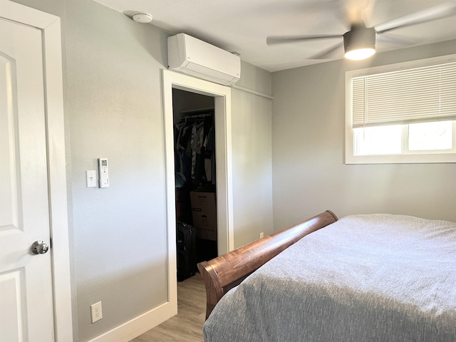 550 Kailana St, Wailuku, HI 96793 - bedroom featuring a wall mounted AC, light wood-type flooring, a closet, a walk in closet, and baseboards