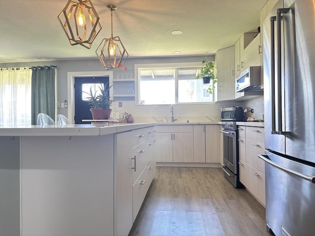550 Kailana St, Wailuku, HI 96793 - kitchen featuring stainless steel appliances, light countertops, light wood-type flooring, and a sink