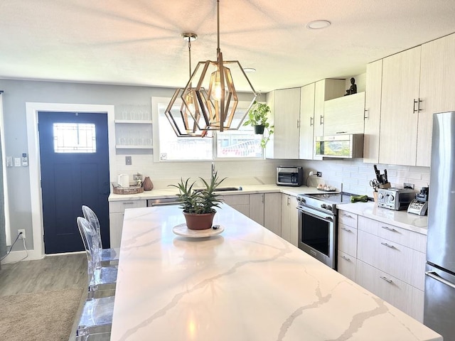 550 Kailana St, Wailuku, HI 96793 - kitchen with stainless steel appliances, backsplash, a chandelier, open shelves, and light stone counters