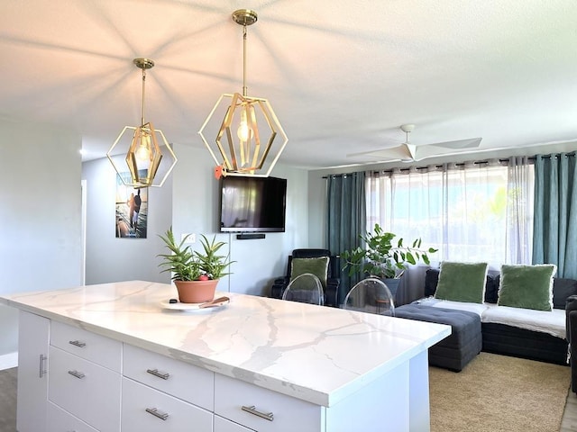 550 Kailana St, Wailuku, HI 96793 - kitchen featuring open floor plan, white cabinetry, light stone countertops, and hanging light fixtures
