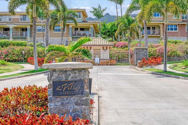 view of home's community with a gate, uncovered parking, and a mountain view
