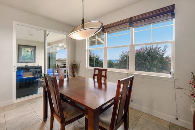 dining space with baseboards, plenty of natural light, and light tile patterned floors