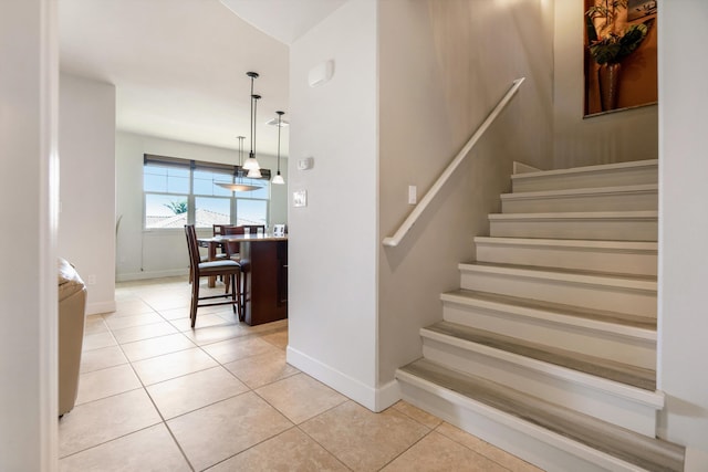 stairway featuring tile patterned flooring and baseboards