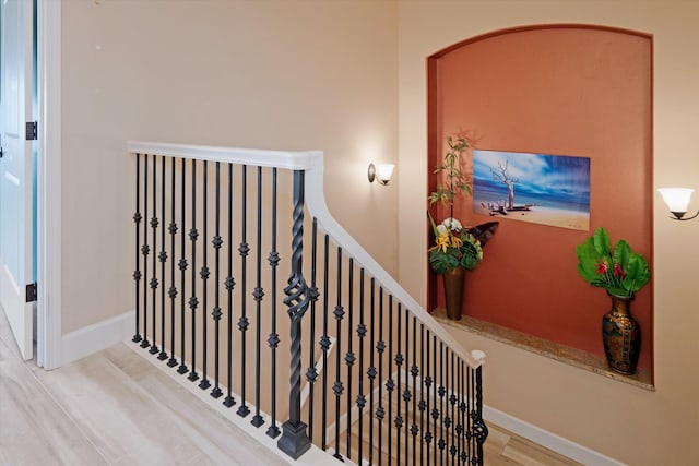 staircase featuring baseboards and wood finished floors