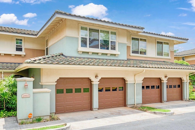 view of front of home featuring a garage, stucco siding, driveway, and a tile roof