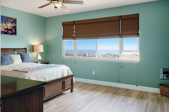 bedroom featuring baseboards, ceiling fan, and light wood finished floors