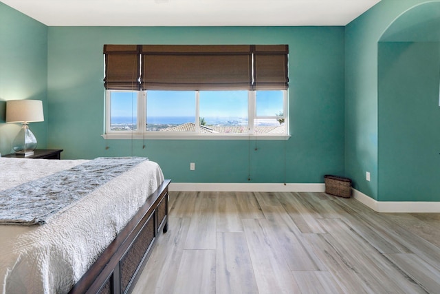 bedroom with baseboards and light wood finished floors