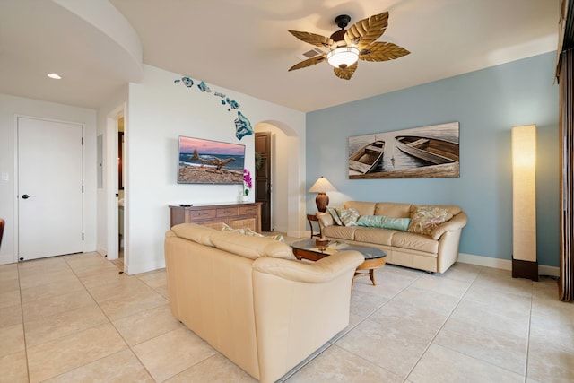 living room with ceiling fan, arched walkways, light tile patterned floors, baseboards, and recessed lighting