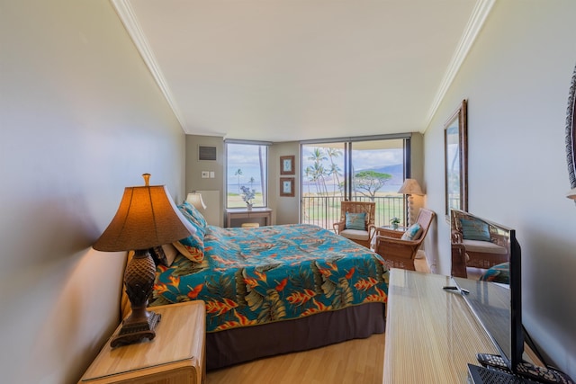 bedroom with access to outside, wood-type flooring, expansive windows, and crown molding