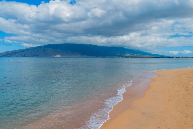 view of water feature with a mountain view and a view of the beach