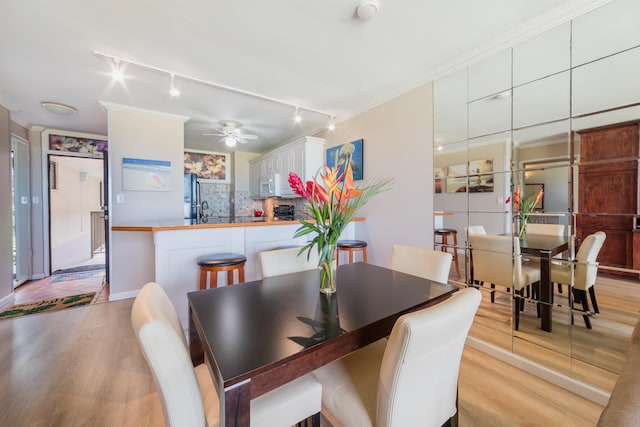 dining space with light wood-type flooring, ceiling fan, and crown molding