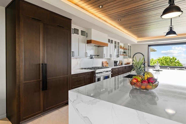 kitchen with wooden ceiling, white cabinets, hanging light fixtures, premium appliances, and light stone counters