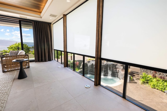 sunroom featuring a tray ceiling and wood ceiling