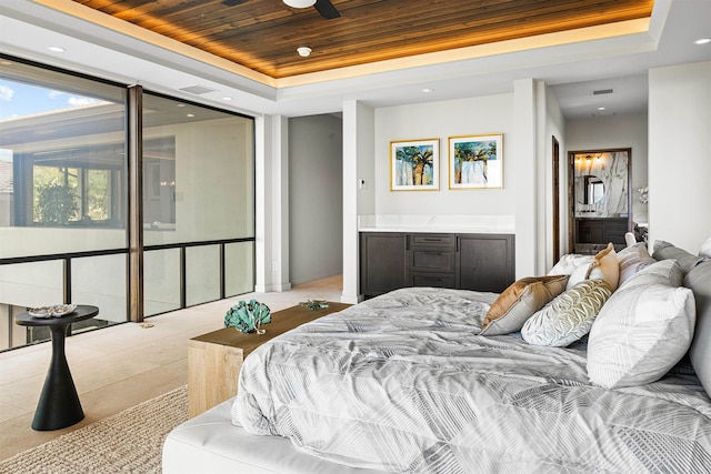 bedroom with ensuite bathroom, a raised ceiling, and wooden ceiling