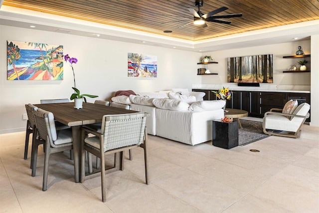 living room with a raised ceiling, ceiling fan, and wooden ceiling