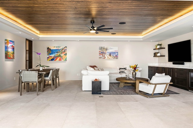 living room with a tray ceiling, ceiling fan, and wooden ceiling