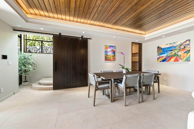 dining area featuring a barn door, a raised ceiling, and wooden ceiling