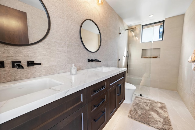 bathroom featuring tiled shower, tile patterned floors, vanity, and toilet