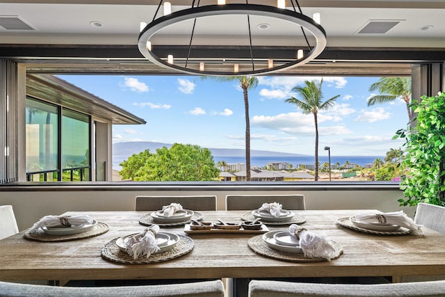 dining space featuring a chandelier and a water and mountain view