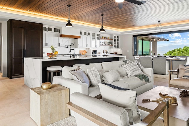 living room with ceiling fan, wood ceiling, and sink