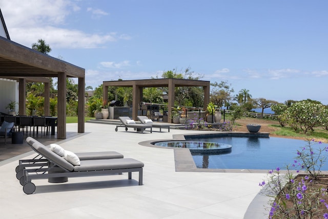 view of swimming pool with an in ground hot tub, a patio, and exterior kitchen