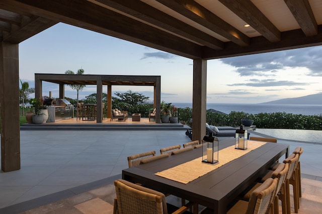 view of patio featuring a water and mountain view, a swimming pool, and exterior kitchen