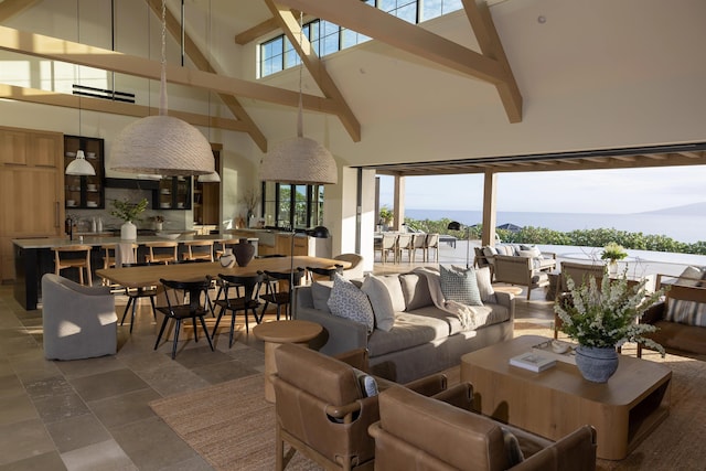 living room featuring a high ceiling, a water view, and beam ceiling