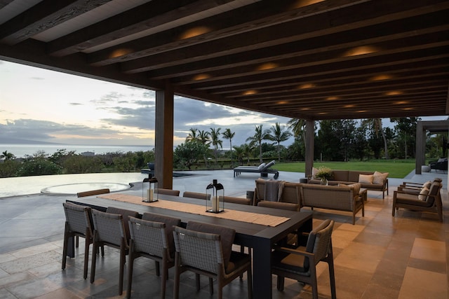 patio terrace at dusk featuring an outdoor living space and a yard