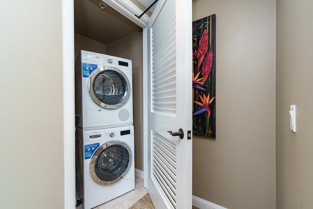 laundry room with light tile patterned floors and stacked washer / drying machine