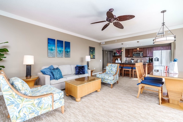 living room with ceiling fan and ornamental molding