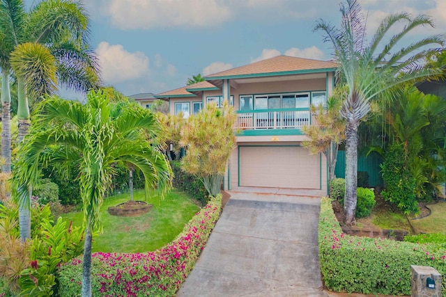 view of front of home with a front yard, a balcony, and a garage