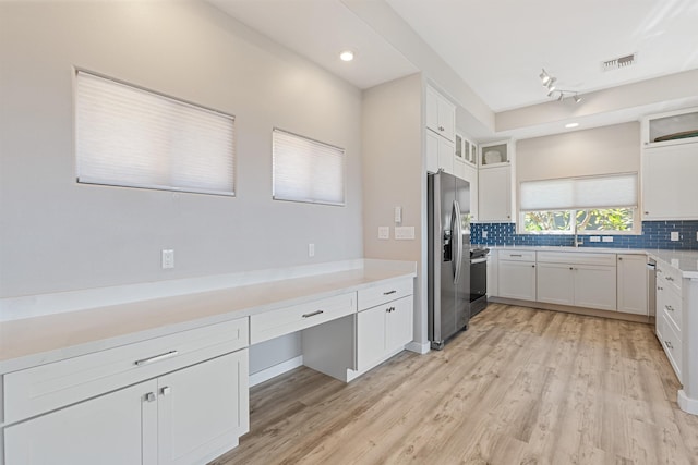 kitchen featuring backsplash, white cabinets, stainless steel appliances, and light wood-type flooring