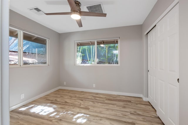 unfurnished bedroom featuring ceiling fan, a closet, and light hardwood / wood-style flooring