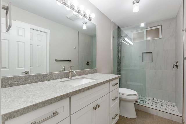 bathroom featuring vanity, toilet, and a shower with door