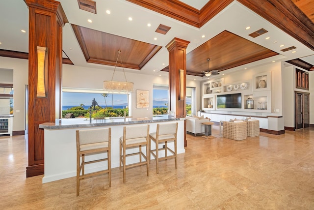 kitchen with kitchen peninsula, wood ceiling, a breakfast bar, ceiling fan with notable chandelier, and pendant lighting