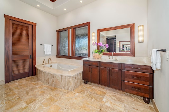 bathroom featuring vanity and tiled tub