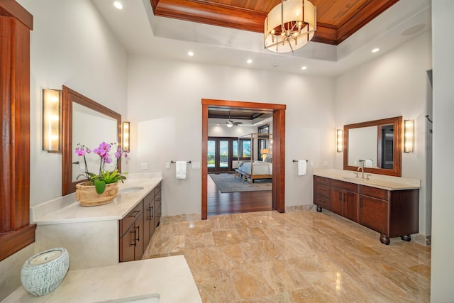 bathroom with crown molding, a towering ceiling, vanity, and a notable chandelier