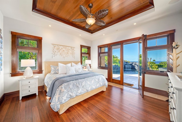 bedroom featuring access to exterior, dark hardwood / wood-style floors, ceiling fan, and a raised ceiling