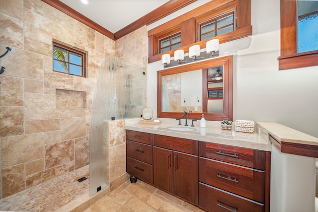 bathroom featuring vanity, a shower, and crown molding