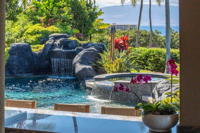 view of pool featuring pool water feature and an in ground hot tub