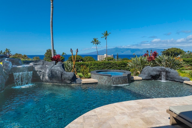 view of swimming pool with an in ground hot tub, pool water feature, and a water and mountain view